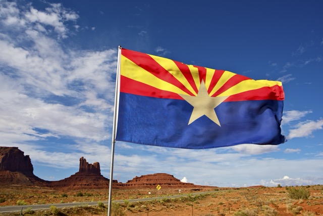 Arizona flag in front of rocky outcroppings
